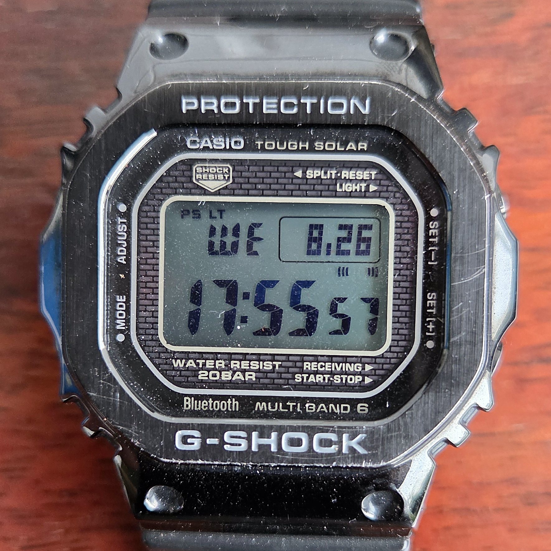 The metal square face on, with the screwed-down bezel visible.