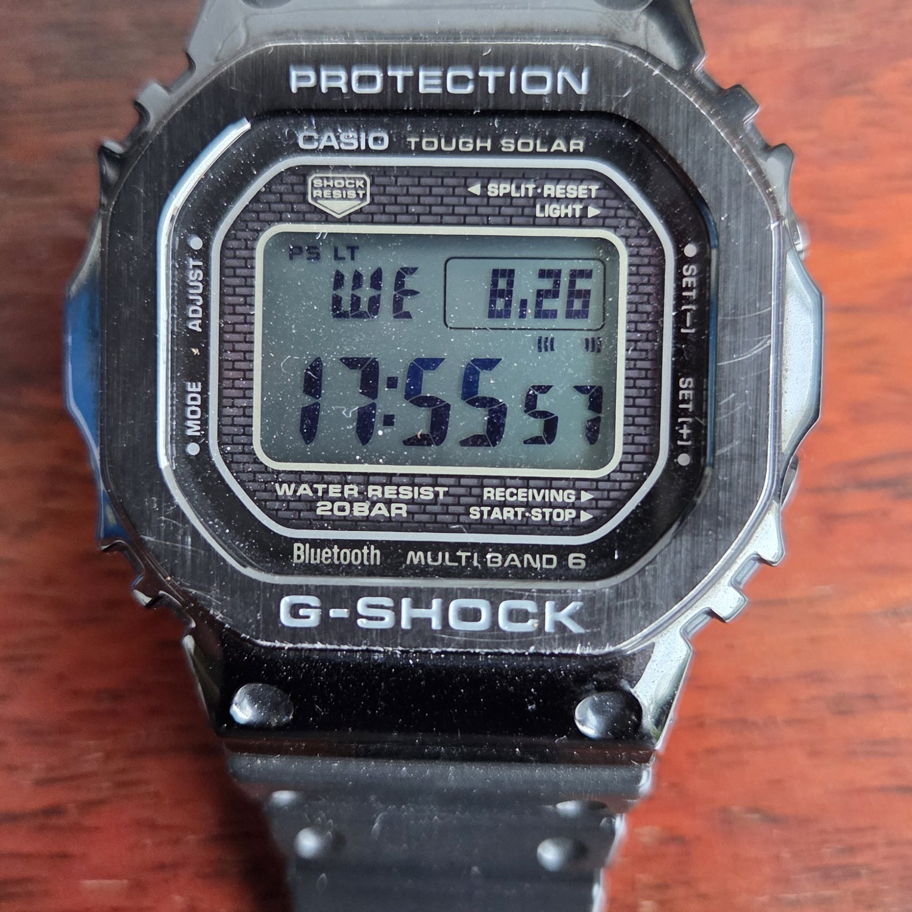 The metal square face on, with the screwed-down bezel visible.