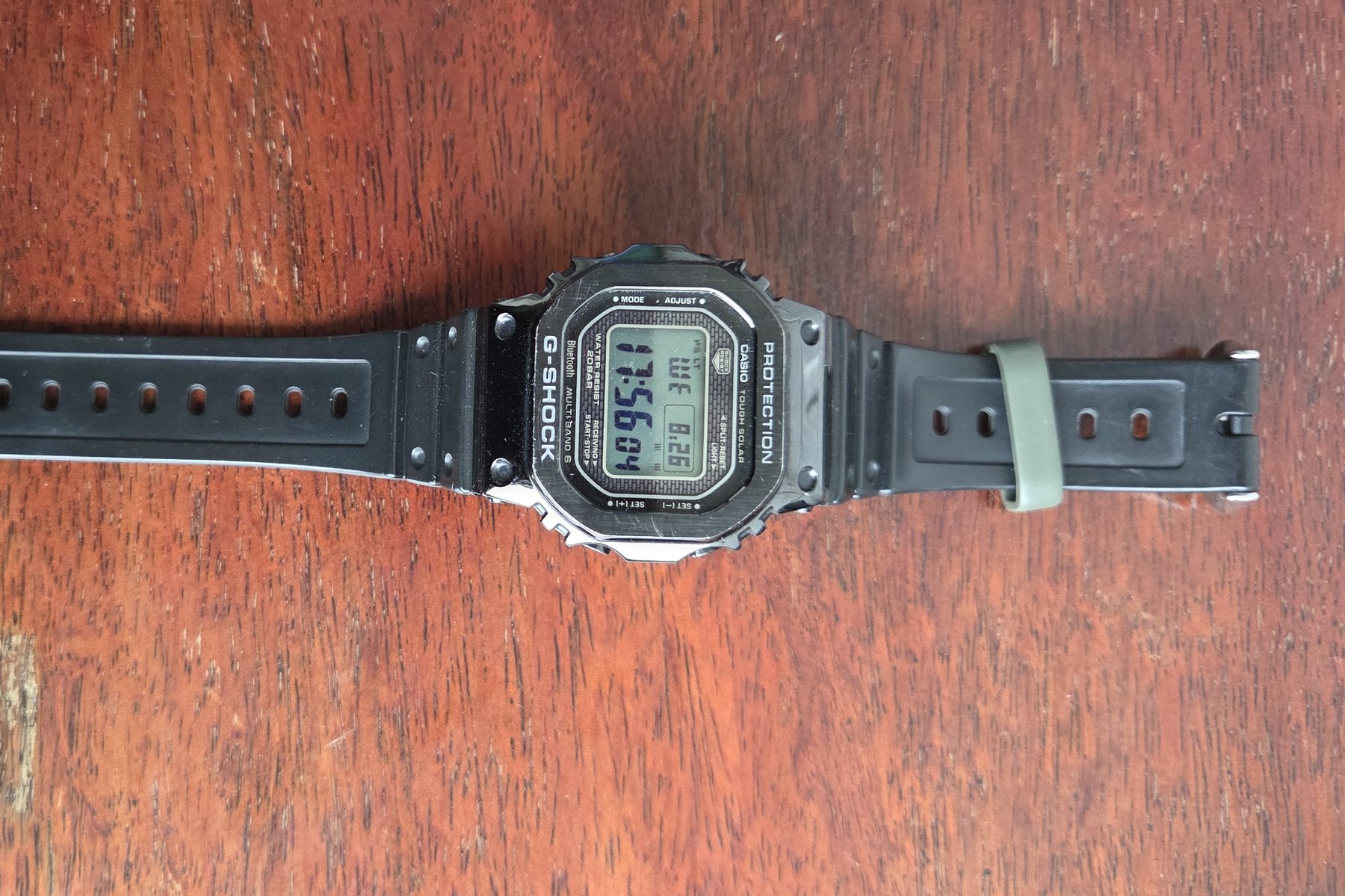 The whole watch with its resin strap laid out flat.