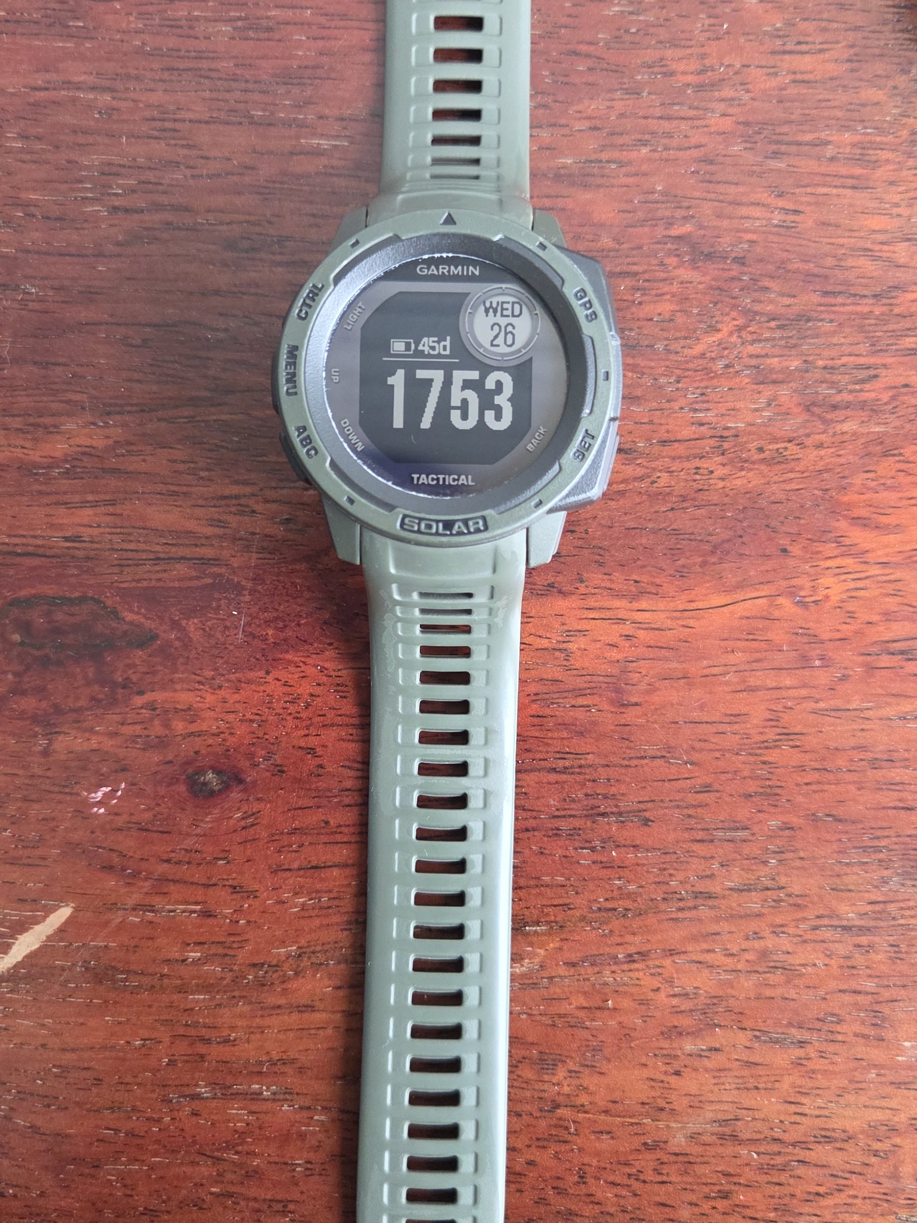 The whole watch laid out with both halves of the silicone strap extended.