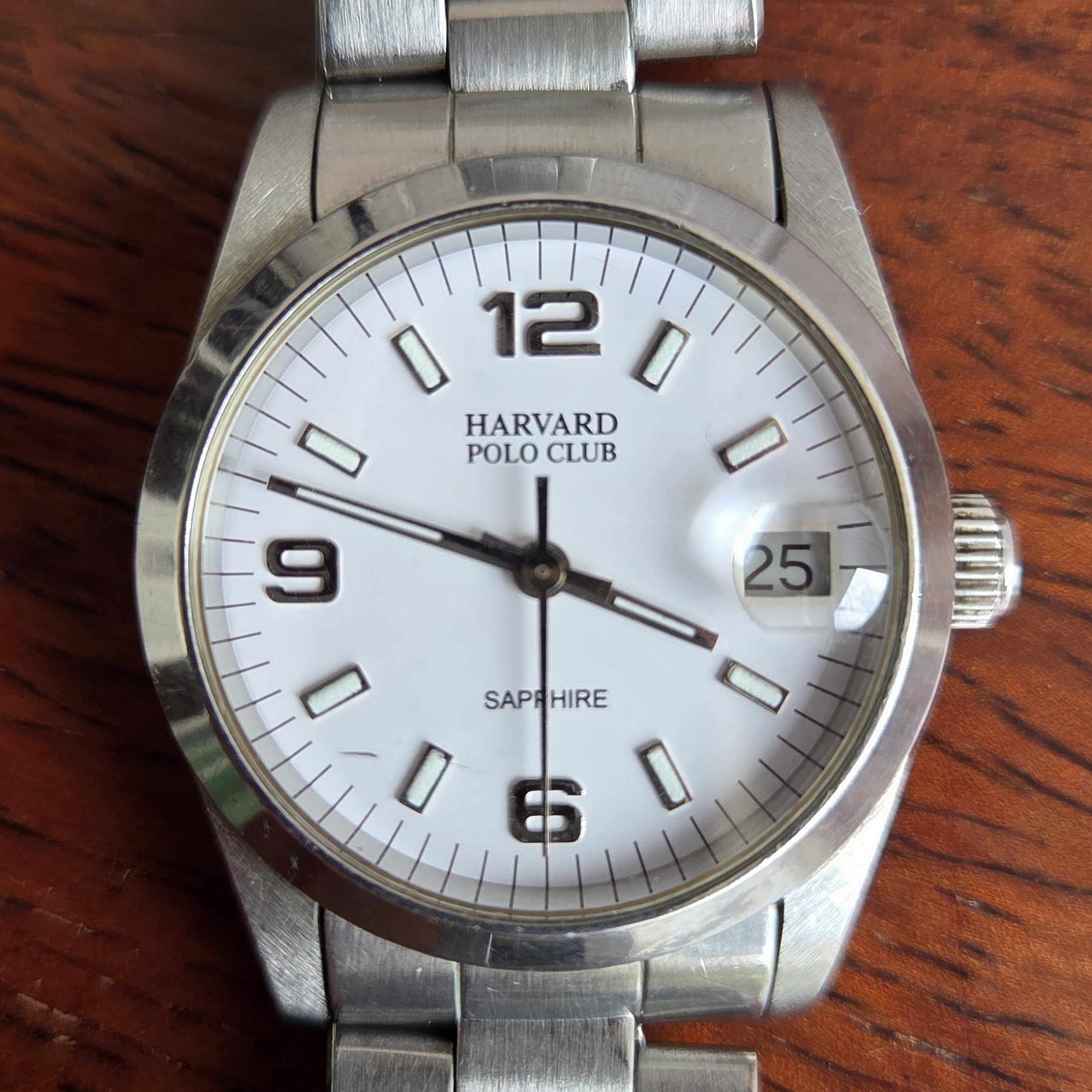 A steel Harvard Polo Club wristwatch with a silver dial and a date window, on a steel bracelet.