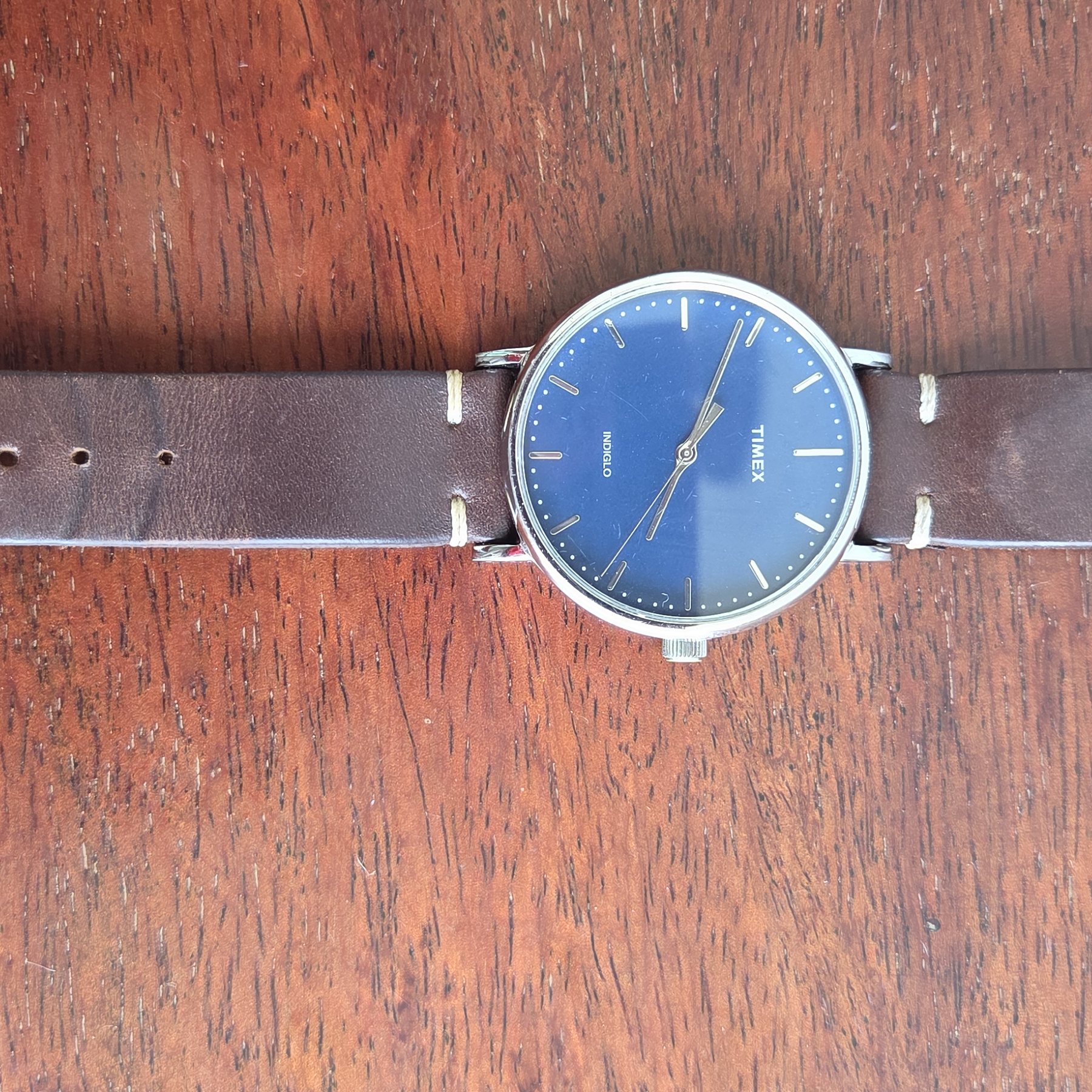 The whole watch laid out flat with the leather strap extended.
