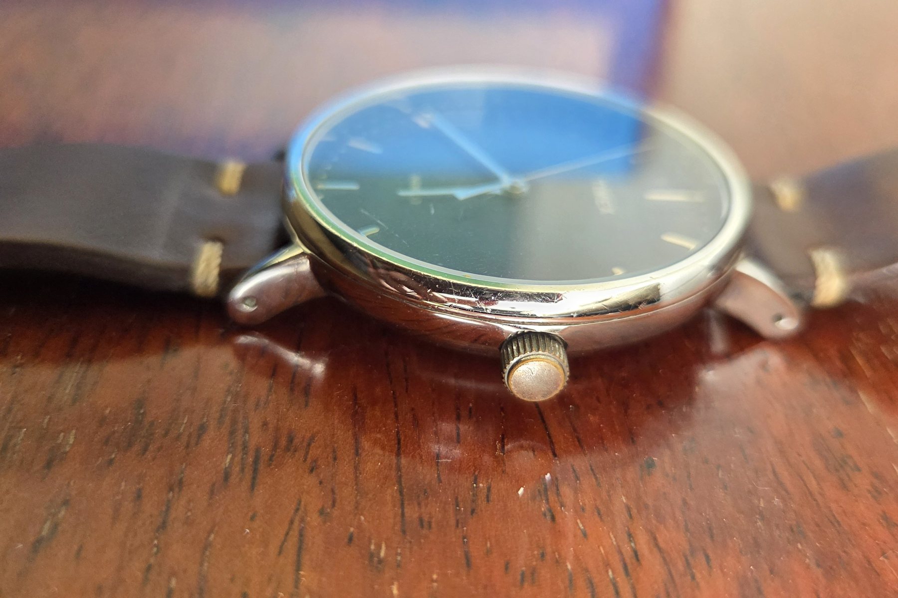 Profile view showing the domed crystal, the polished case side and the crown.