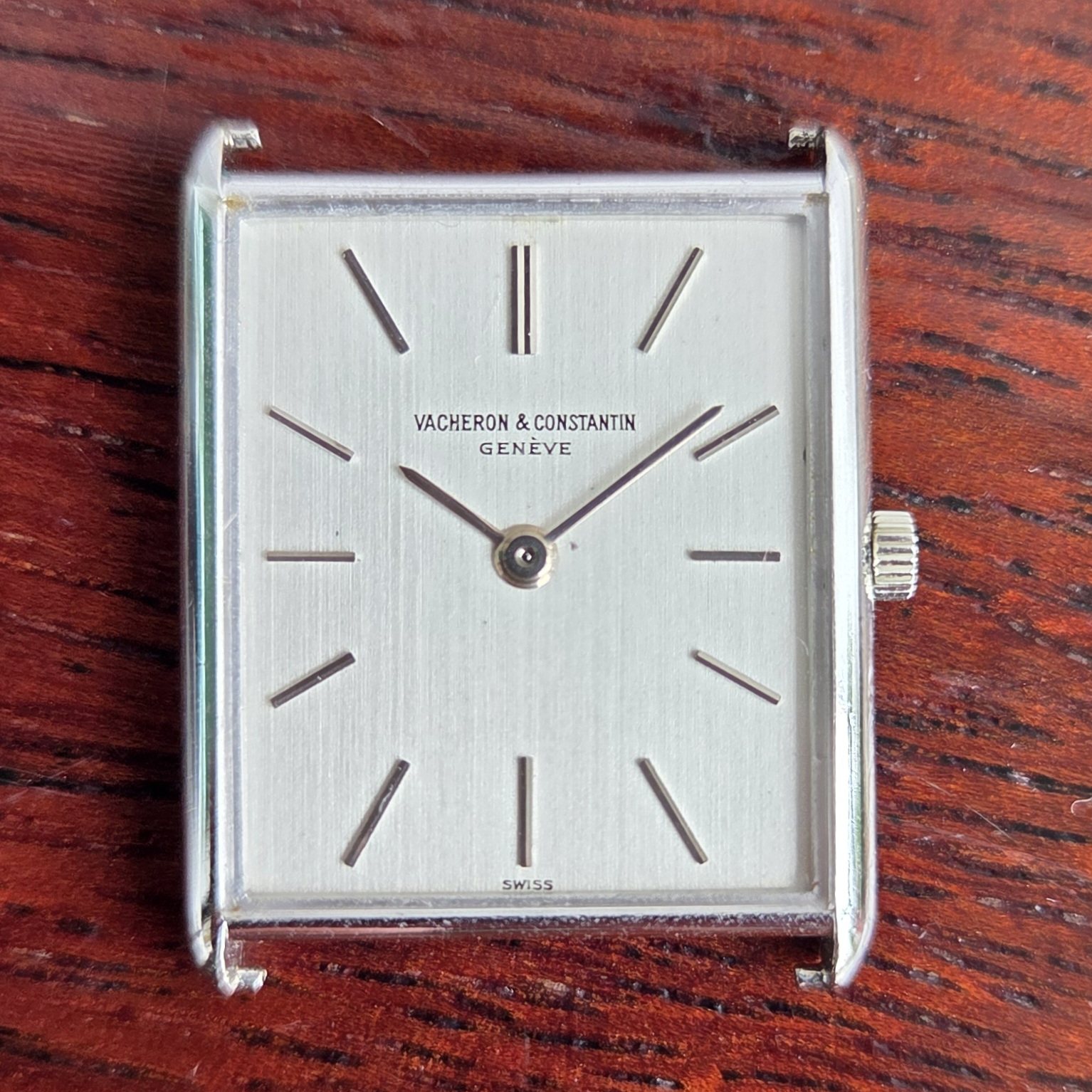 The dial photographed close, showing the vertical brushing across the silvered surface.
